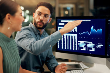 man and woman in front of computer with marketing data